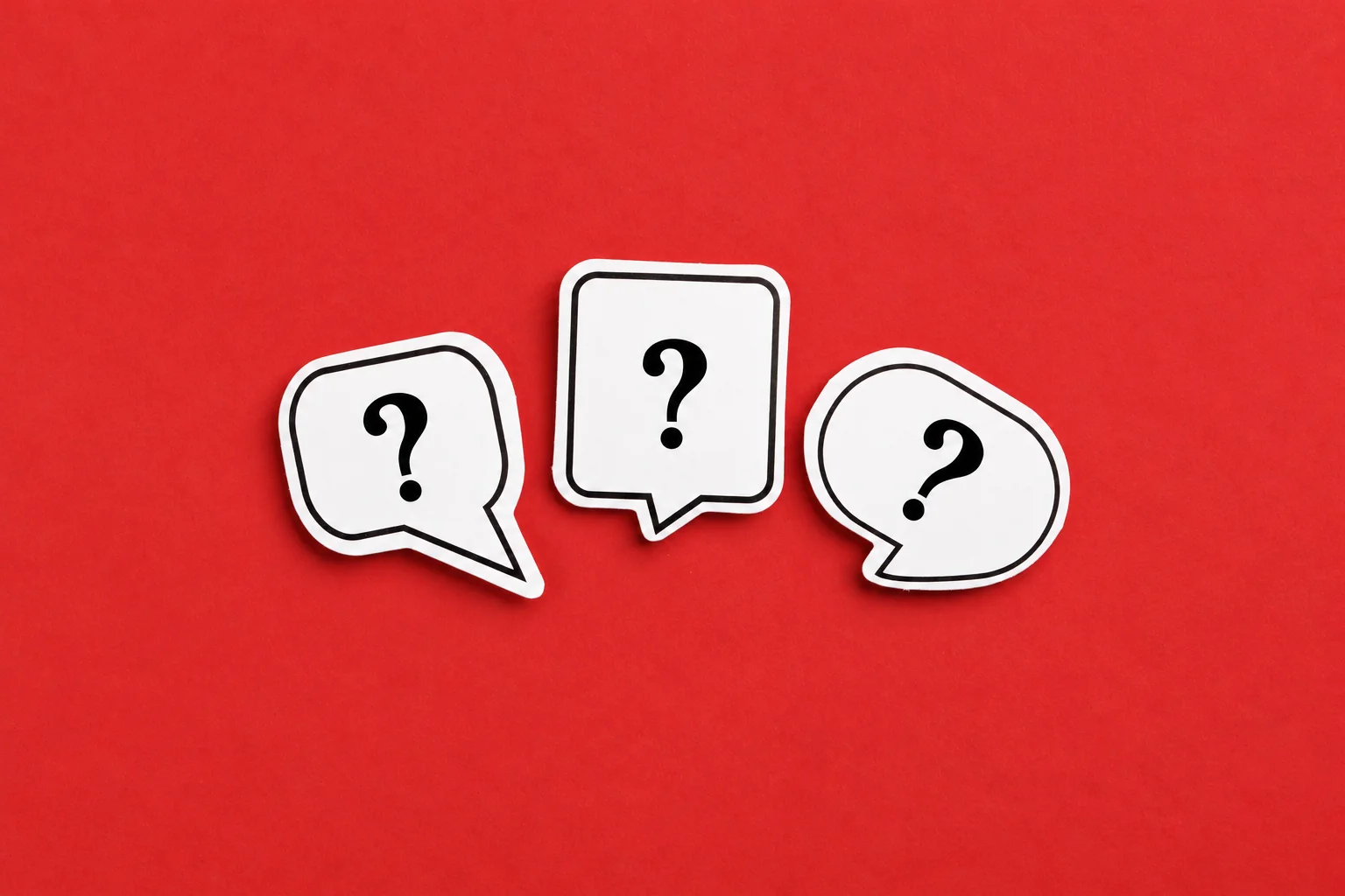 Three white paper speech bubbles with question marks, on a red background.